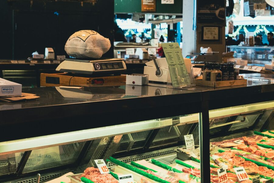 Butcher counter with raw meat and a weighing scale, the kind of setup Atria Manager runs