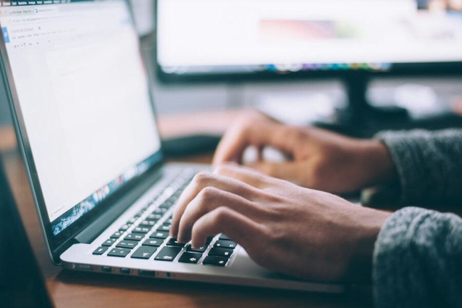 Person checking WooCommerce order emails on a laptop