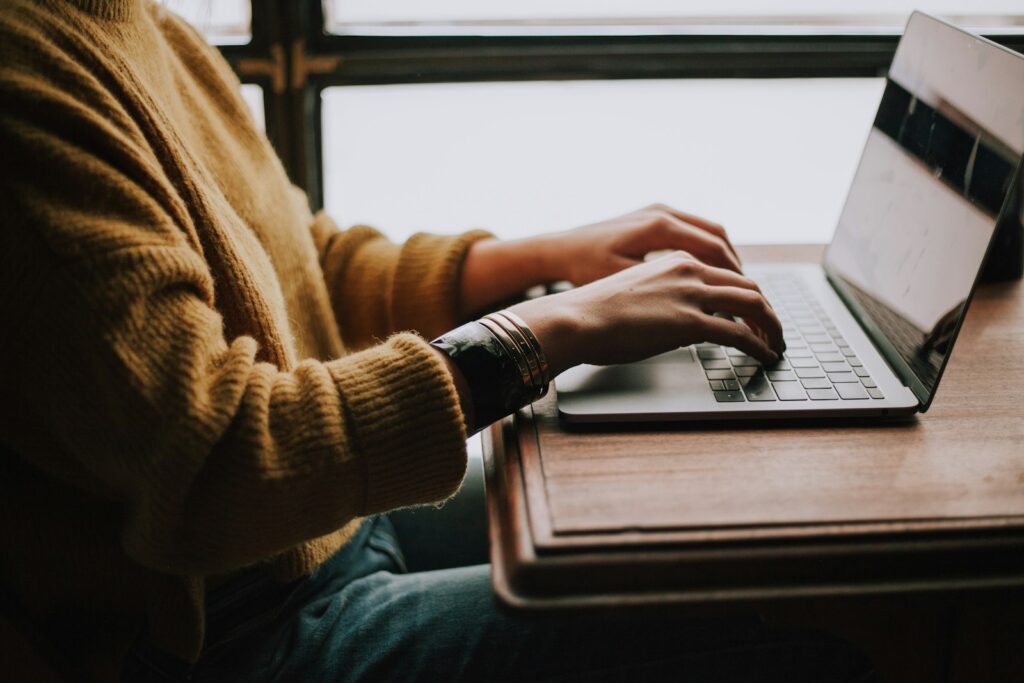 Developer editing a WooCommerce email template on a laptop