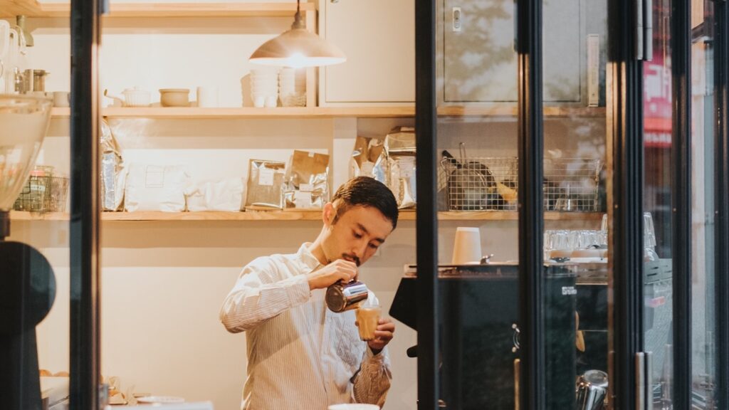 Small business owner serving a customer at a shop window